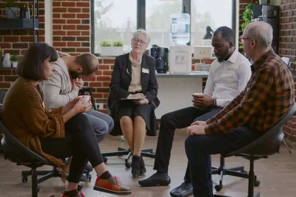 woman-therapist-people-with-addiction-meeting-aa-group-therapy-session-patients-circle-attending-rehabilitation-program-recover-from-alcoholism-mental-health-issues