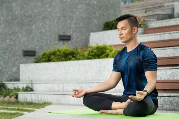 man-mediating-relaxing-outside