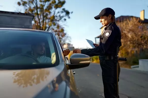 Police officer asking for a persons drivers license at a traffic stop.