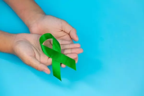 world-mental-health-day-green-ribbon-put-human-s-hands-blue-background